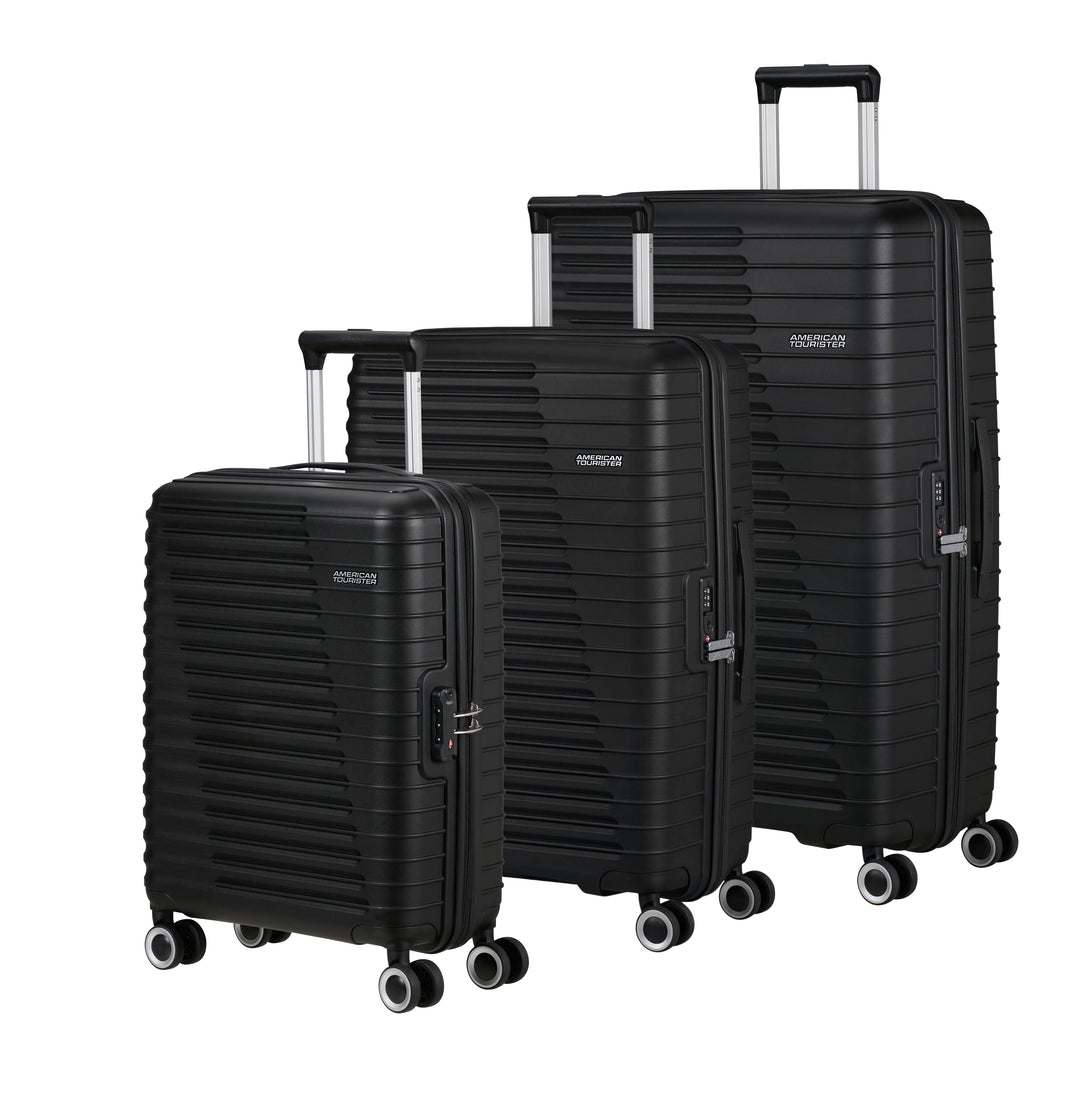 Set of three black American Tourister suitcases of different sizes on a white background
