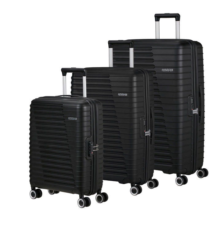 Set of three black American Tourister suitcases of different sizes on a white background