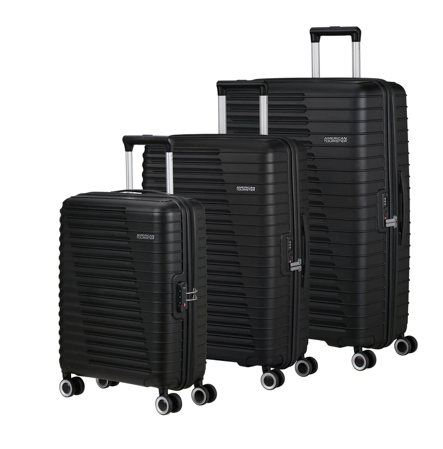 Set of three black American Tourister suitcases of different sizes on a white background