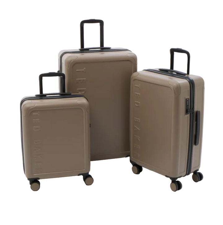 Three hard-shell rolling suitcases in a matching taupe-beige color are arranged by size on a clean white studio background. The embossed brand name 'TED BAKER' is visible on the front of each suitcase, and they have black telescoping handles and wheels.