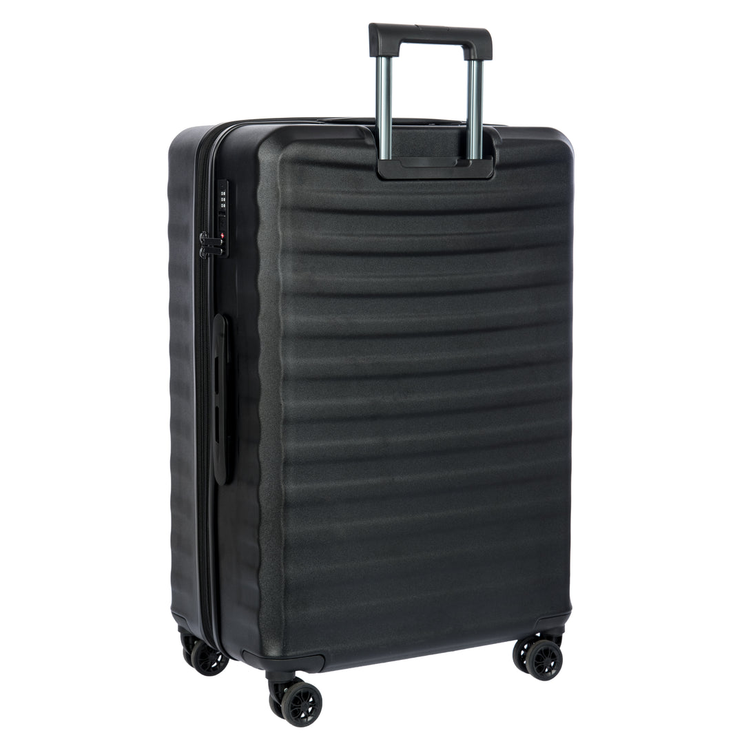 Back of a black Bric's suitcase with a textured surface on a white background