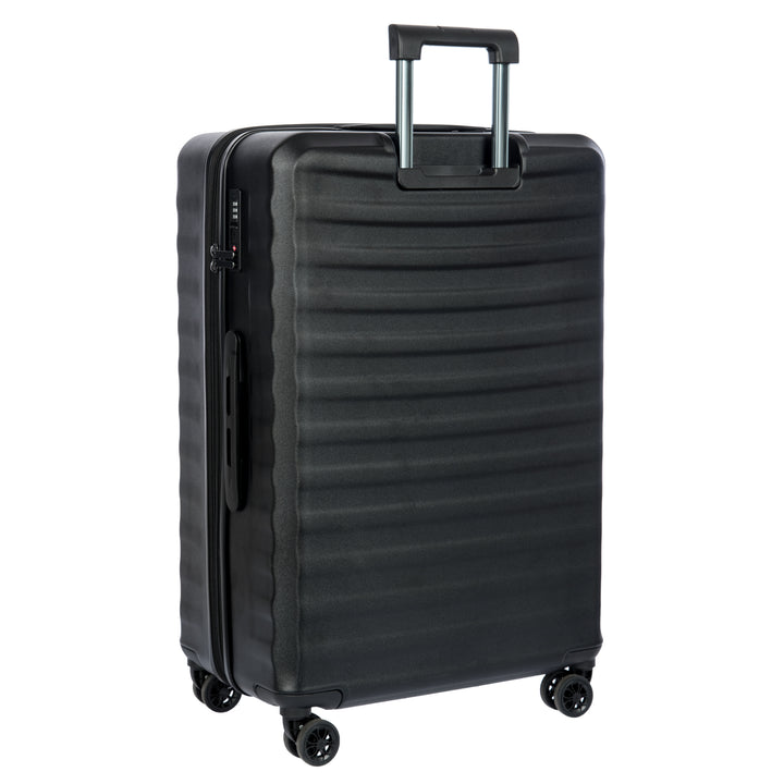Back of a black Bric's suitcase with a textured surface on a white background