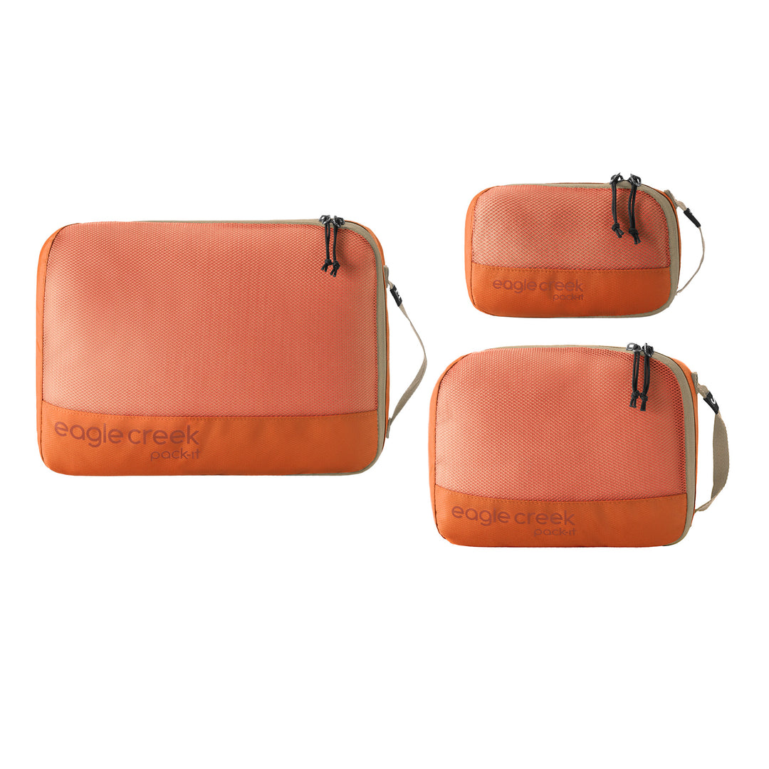 Three orange travel packing cubes with 'eagle creek' branding on a white background