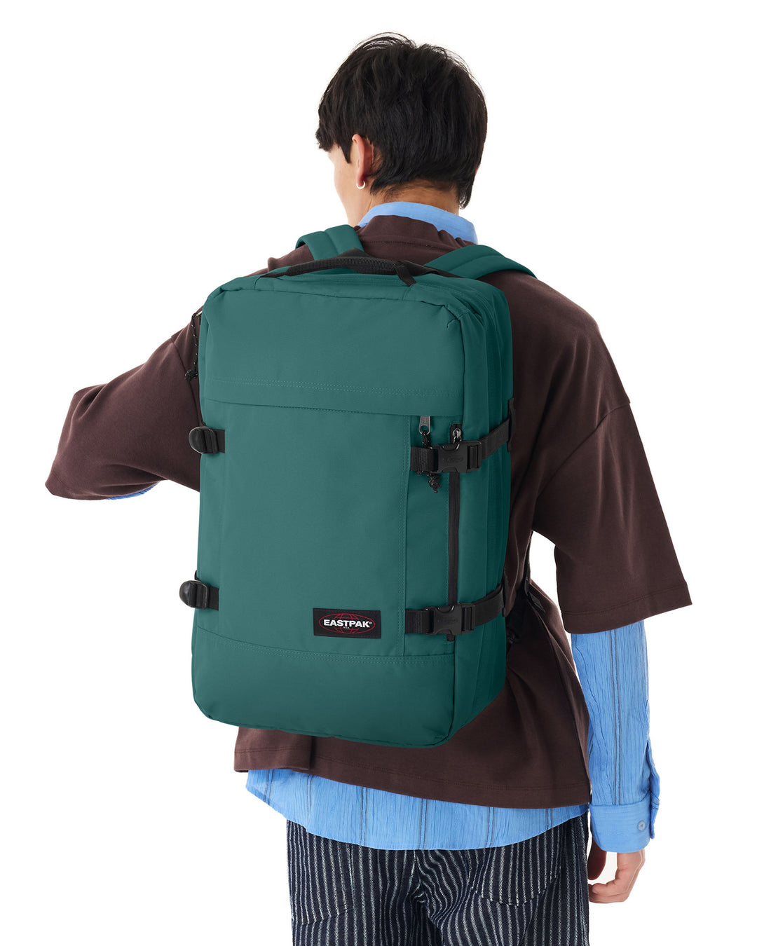Person wearing a green backpack with Eastpak logo on a white background