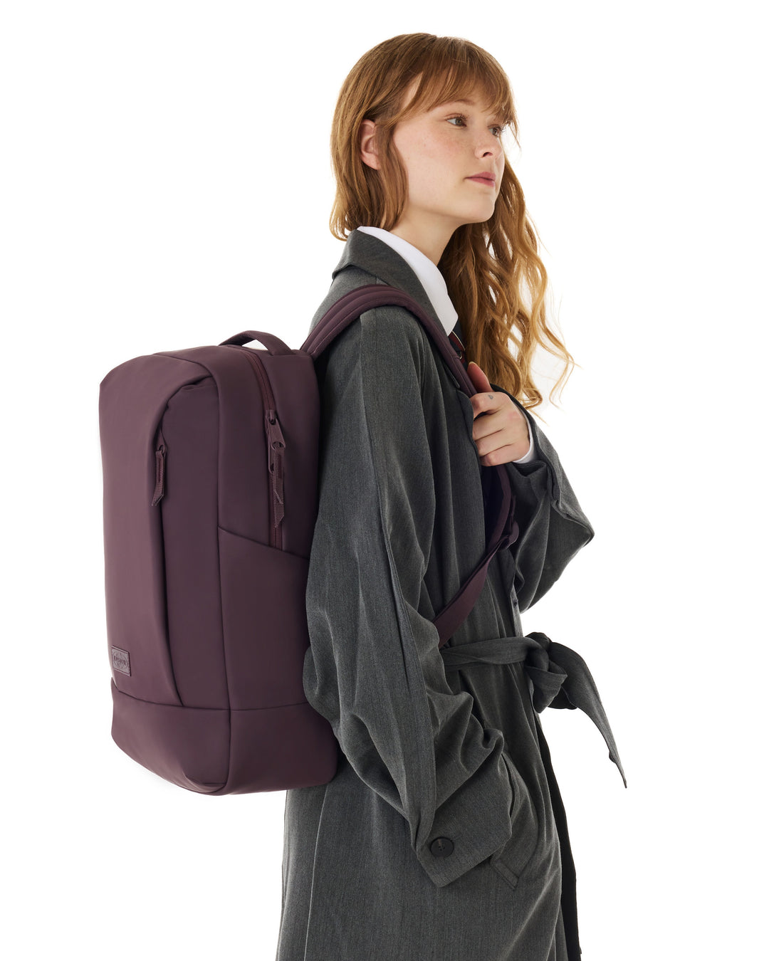 Person wearing a wine backpack and gray coat on a white background