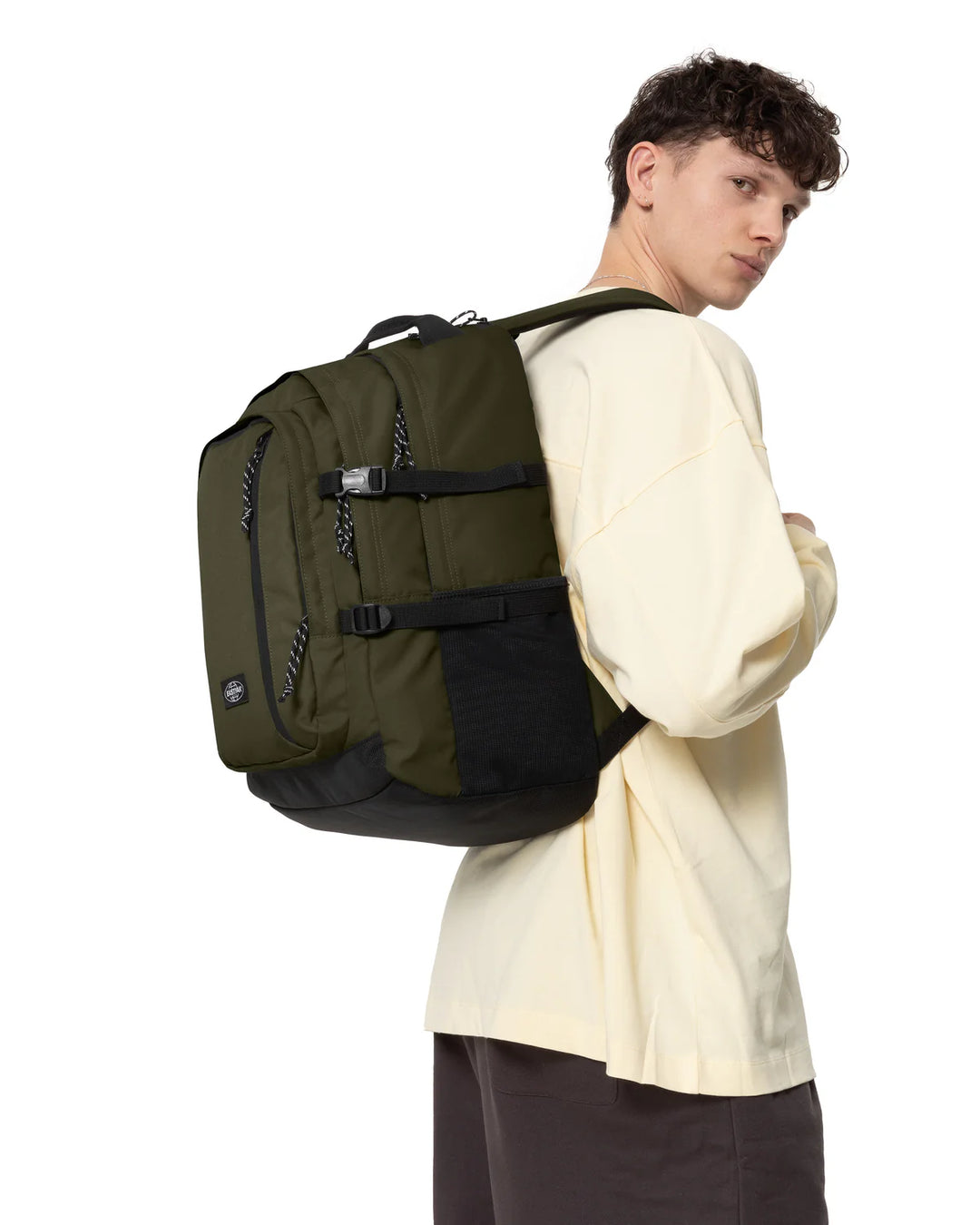 Person wearing a green and black backpack on a white background