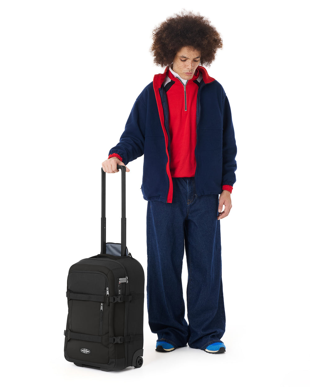 Person wearing a red and blue outfit with a black suitcase on a white background