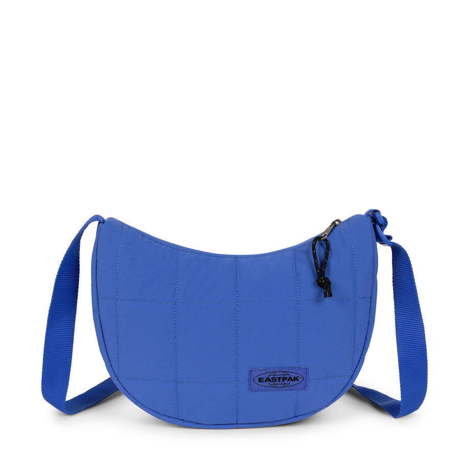 A bright blue quilted crescent-shaped shoulder bag with a matching adjustable strap and a small Eastpak logo patch on the front, set against a plain white background.