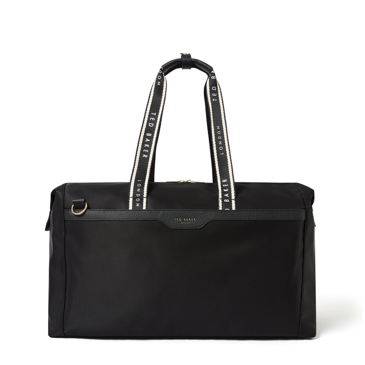 A black Ted Baker duffel bag with white and black patterned shoulder straps and a small gold-tone logo plate on the front.