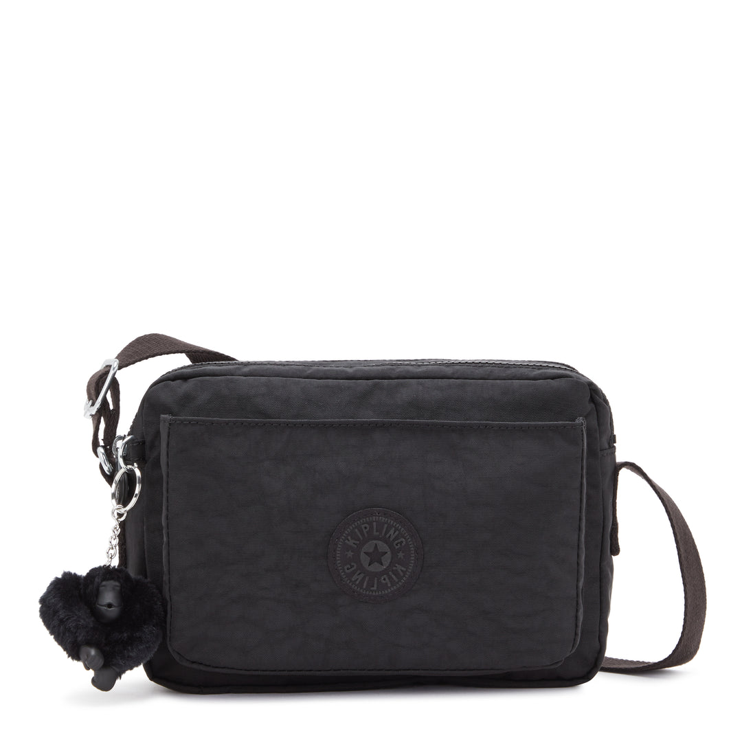 Black crossbody bag with a monkey charm on a white background