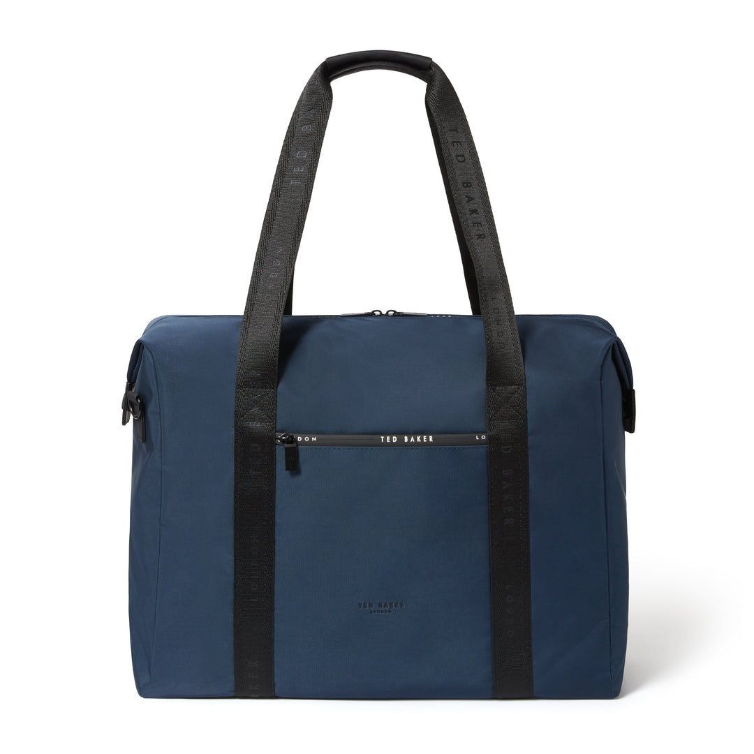 A navy blue Ted Baker travel bag with black shoulder straps and a black front zip pocket, shown on a clean white background.