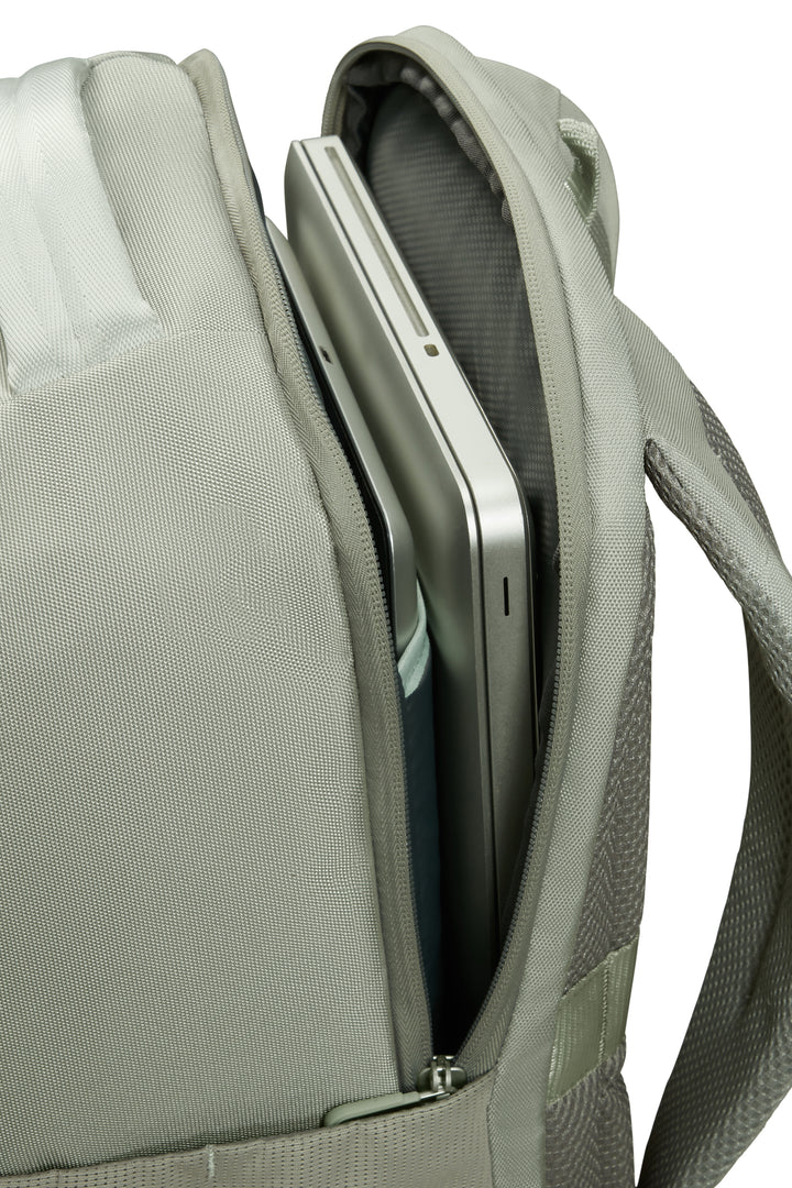 Light green backpack with a compartment holding a silver laptop on a white background