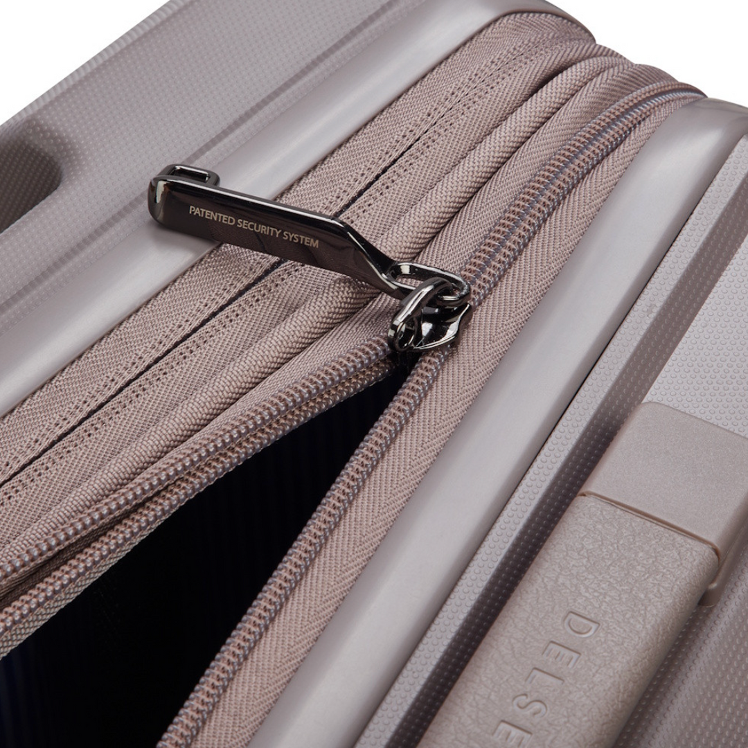 Close-up of a suitcase zipper with a patent label, featuring the brand name 'Delsey'.