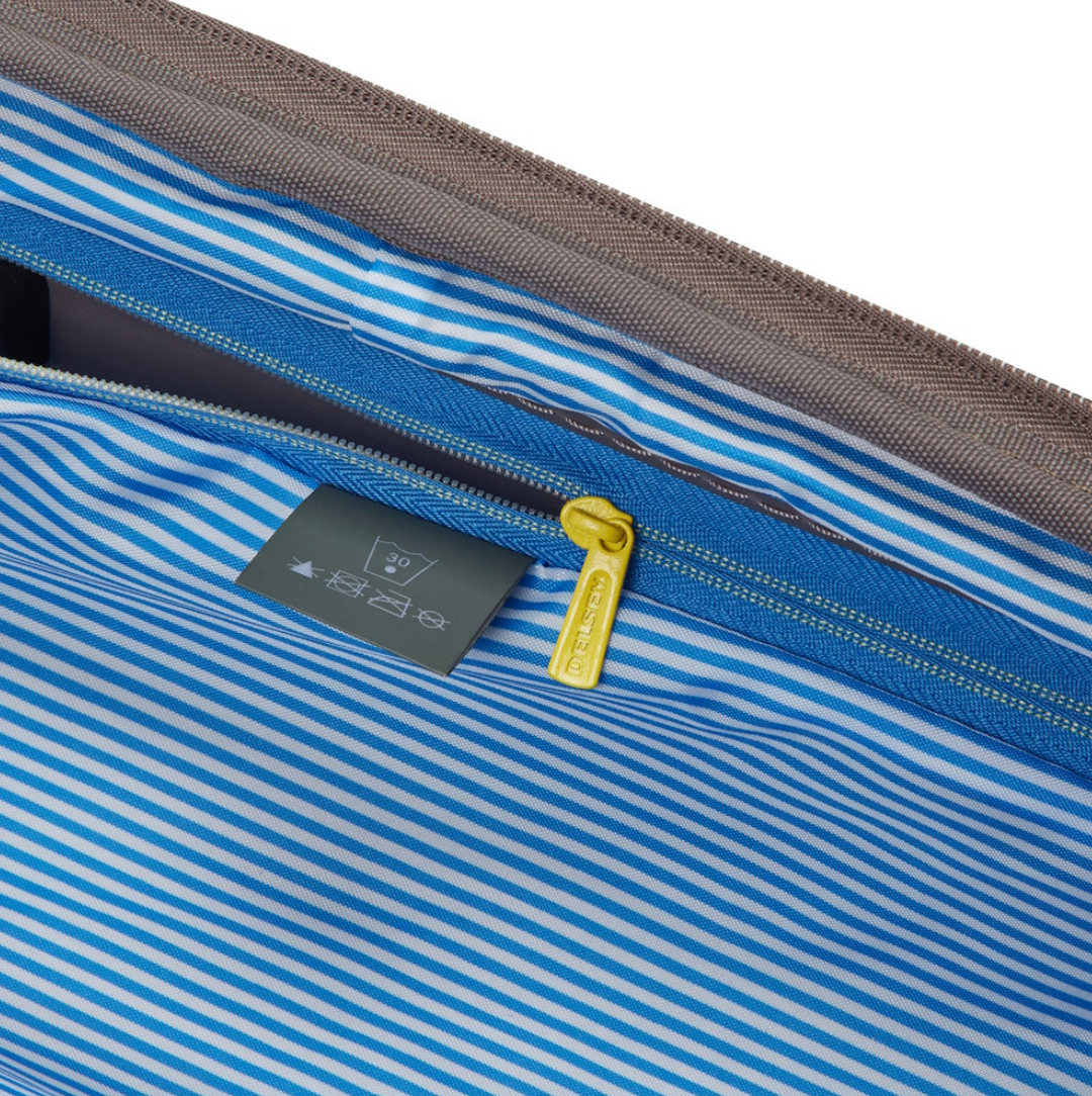 Close-up of a blue striped suitcase lining with a zipper and visible label.