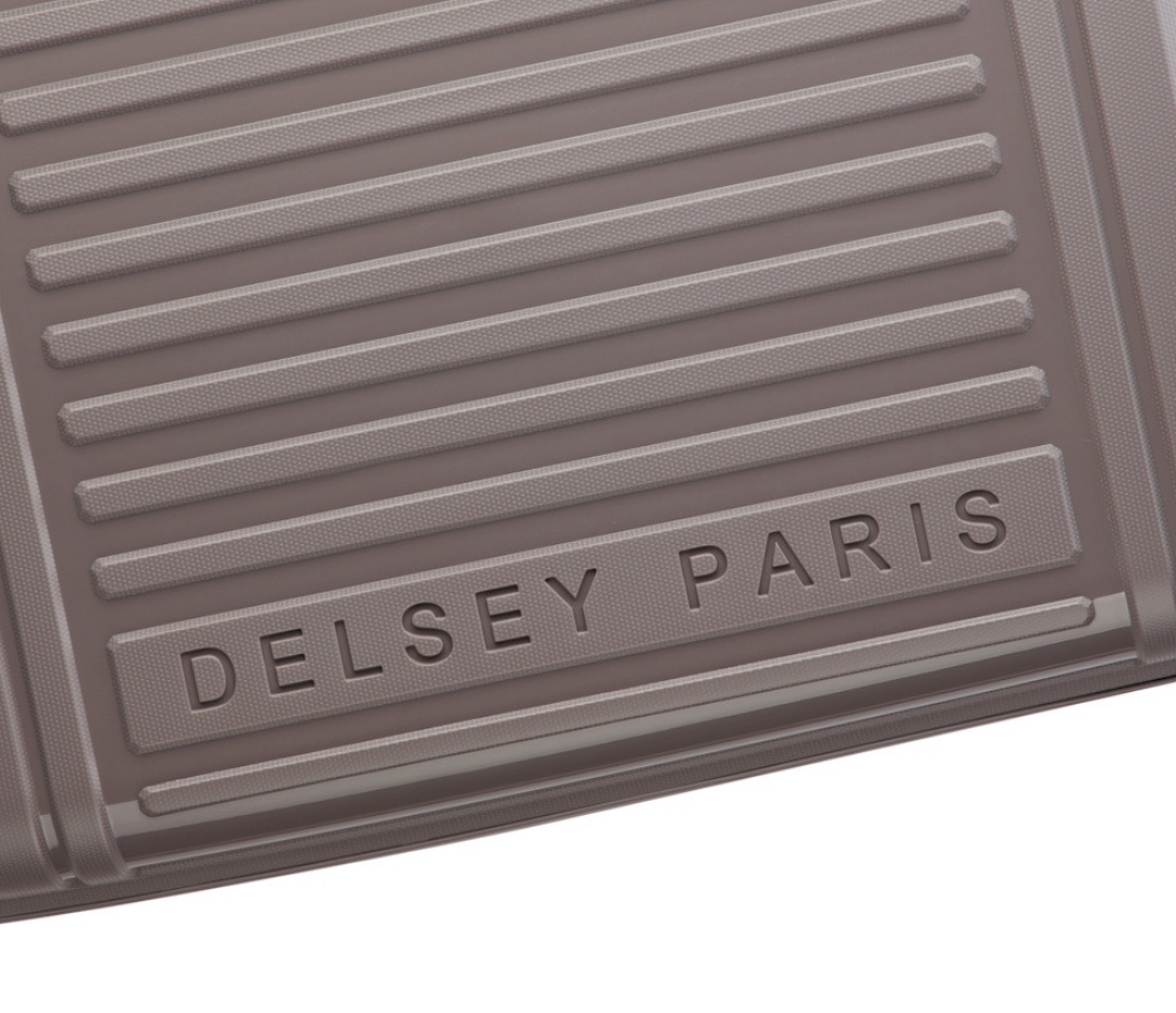 Close-up of a Delsey Paris suitcase with embossed branding on a white background