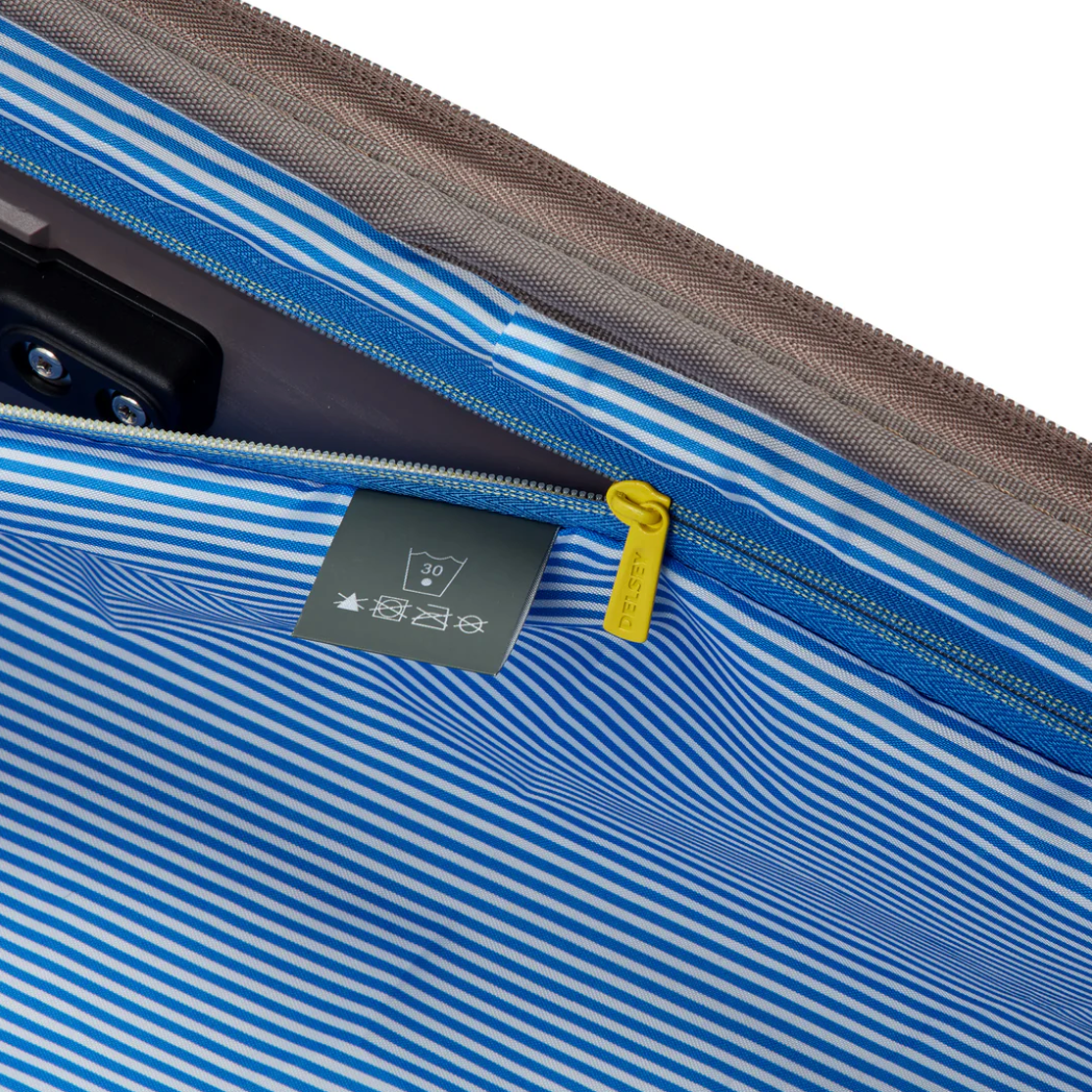 Close-up of a blue and gray striped suitcase lining with a zipper and label.
