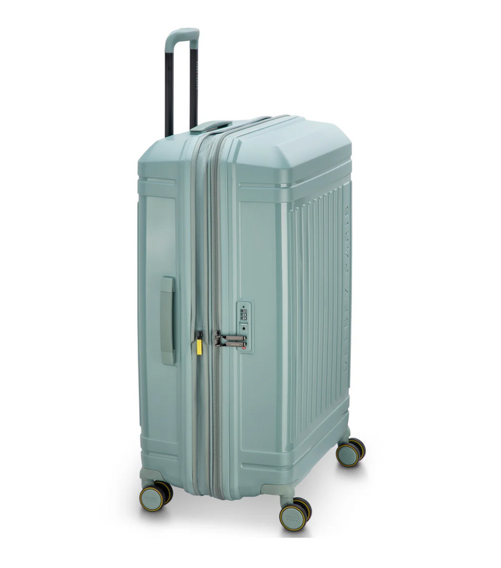 Side angle of a sagre green Delsey Paris suitcase with 4 wheels and side handle on a white background
