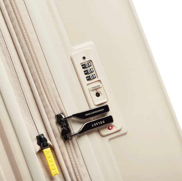 Close-up of a beige suitcase with a combination lock and DELSEY branding on the zip pullers.