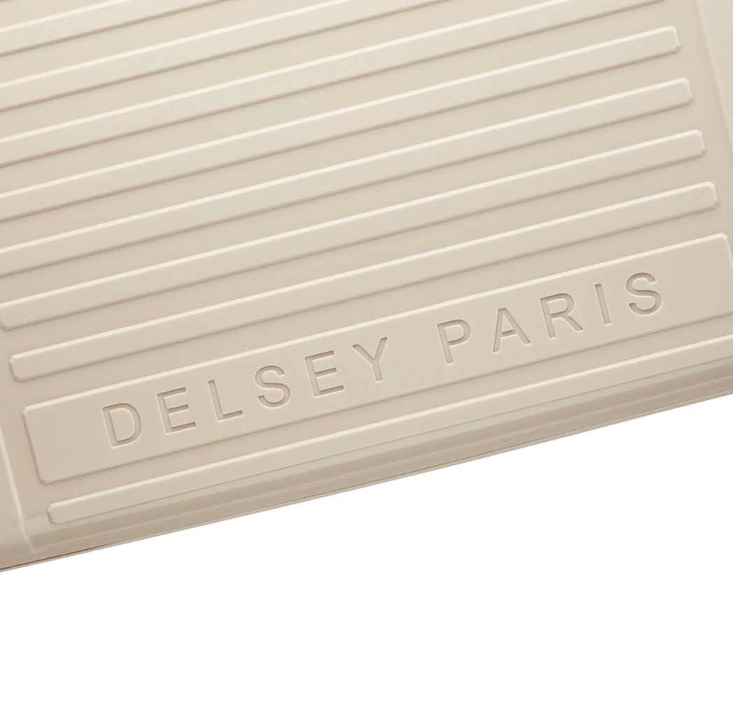 Beige textured suitcase surface with 'Delsey Paris' branding
