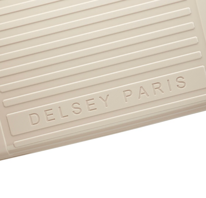 Beige textured suitcase surface with 'Delsey Paris' branding