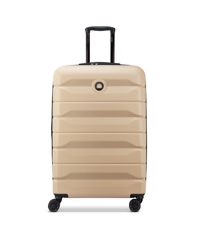 Beige Delsey suitcase with black handle and wheels on a white background