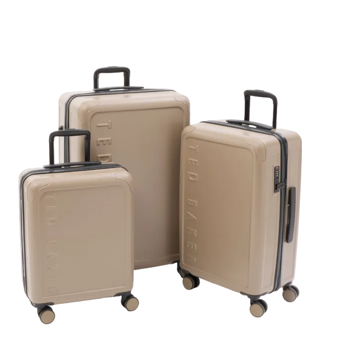 Three beige hard-shell spinner suitcases of different sizes with black handles and trim, standing on a white studio background. The embossed brand name 'TED BAKER' is visible on the suitcases.