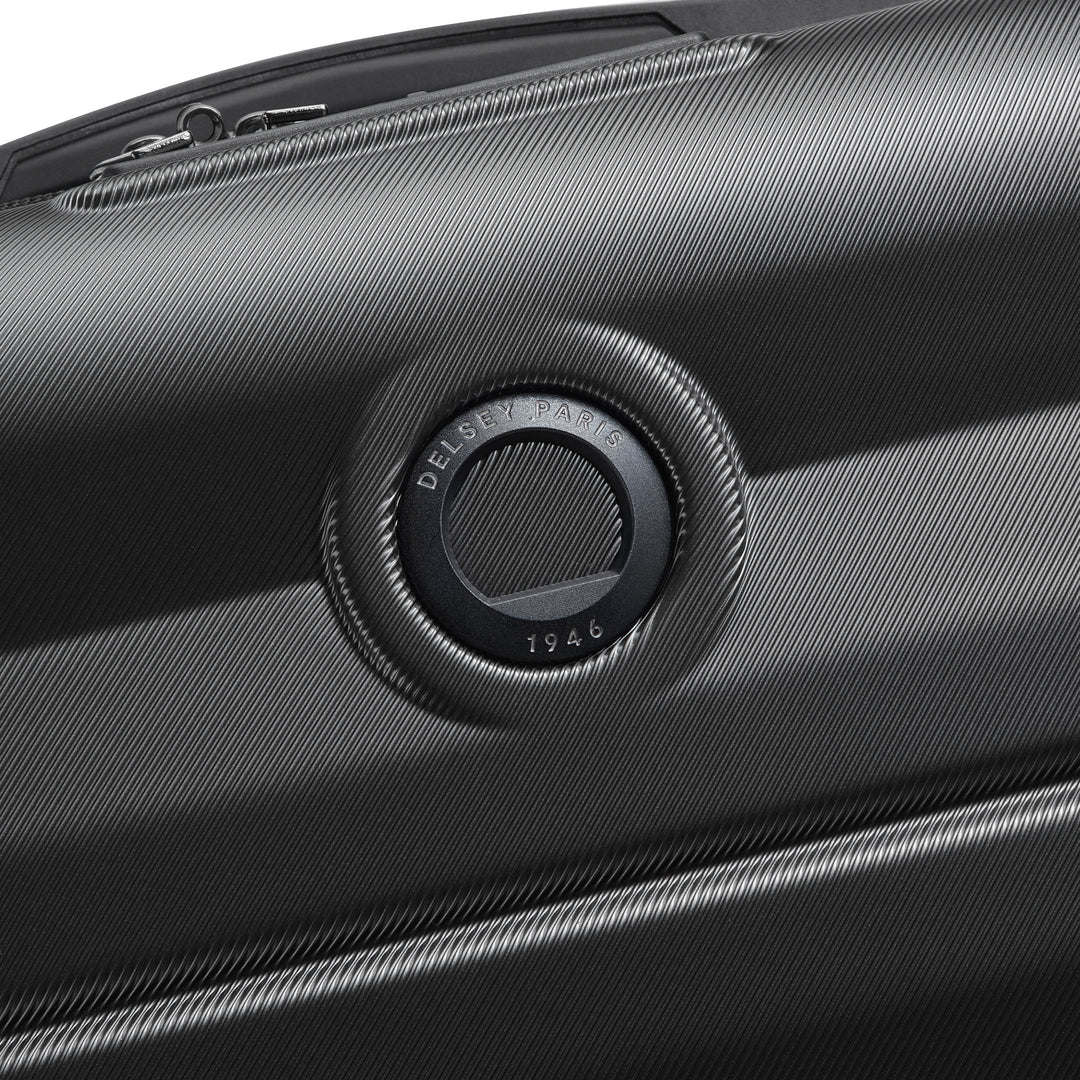 Close-up of a black suitcase with Delsey brand logo on a white background