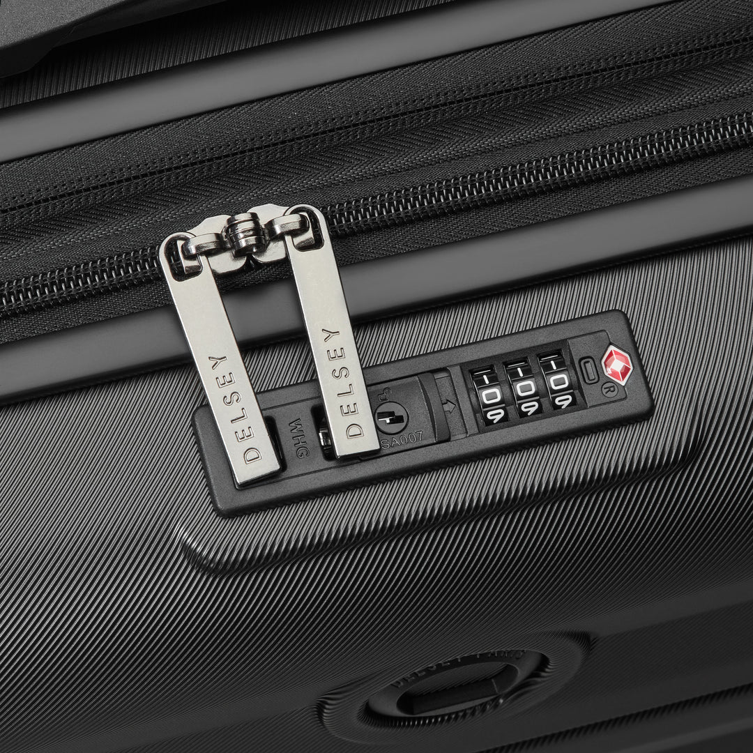 Close-up of a black suitcase with a Delsey lock and combination lock panel.