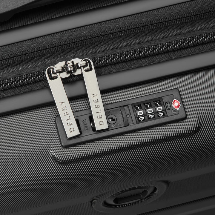 Close-up of a black suitcase with a Delsey lock and combination lock panel.