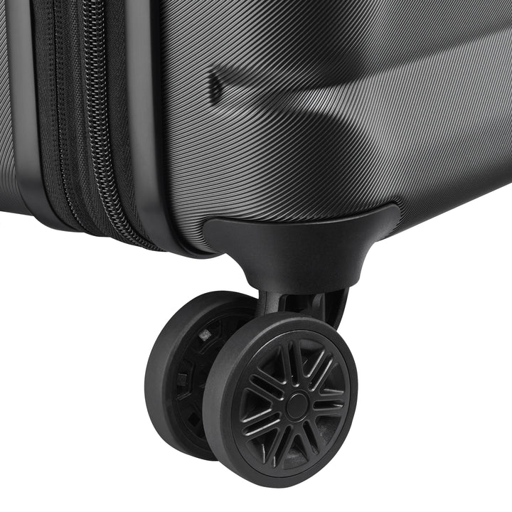 Close-up of a black suitcase wheel on a white background