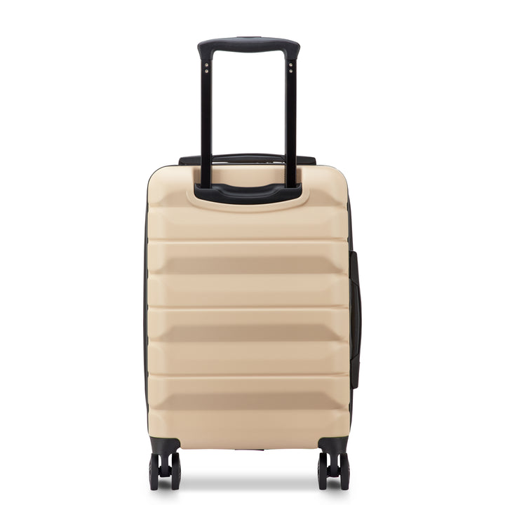 Back of a Beige Delsey suitcase with black handle and wheels on a white background
