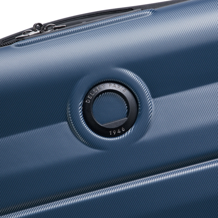 Close-up of a blue suitcase with a brand Delsey logo on a white background