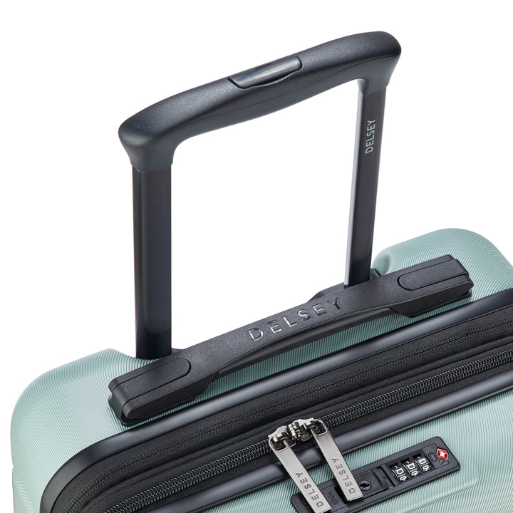 Close-up of a sage green Delsey suitcase with black handle and zipper on a white background